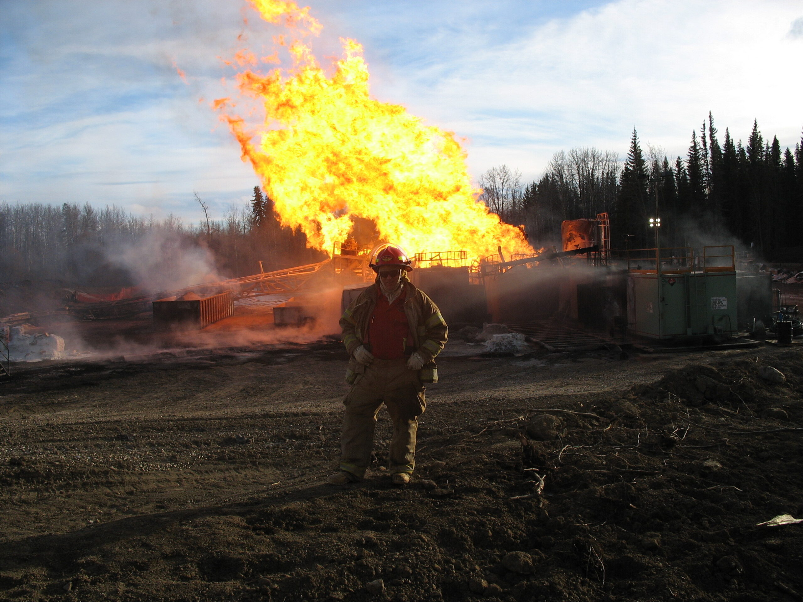 Oil well fire with flames reflected in floodwater , link to 70 Years of Response gallery